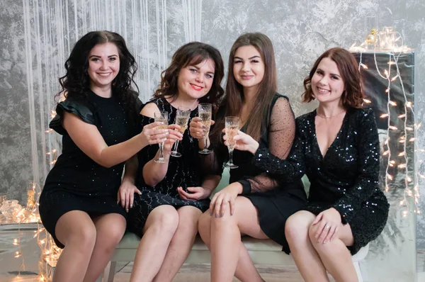 Companhia de mulheres jovens muito agradáveis com copos de vinho de champanhe celebra o Natal, o ano novo — Fotografia de Stock