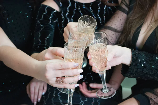 Copos festivos com champanhe em mãos femininas. Celebração de Natal, aniversário, festa de galinha, casamento — Fotografia de Stock