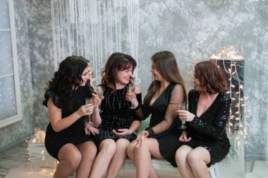 ?şampanya şarap bardakları ile çok güzel genç kadınların ompany Noel kutluyor, yeni yıl. Birbirinie bakın, şakalayın ve eğlenin.