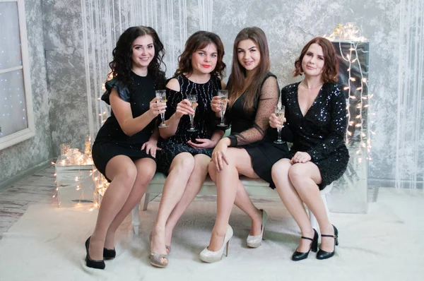 Het gezelschap van zeer mooie jonge vrouwen met glazen champagne wijn viert Kerstmis, het nieuwe jaar. — Stockfoto