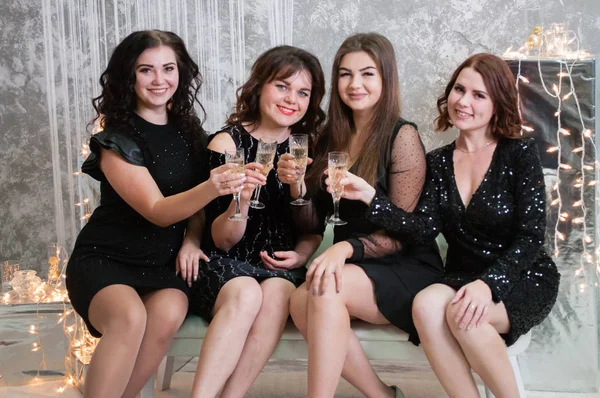 Companhia de mulheres jovens muito agradáveis com copos de vinho de champanhe celebra o Natal, o ano novo — Fotografia de Stock