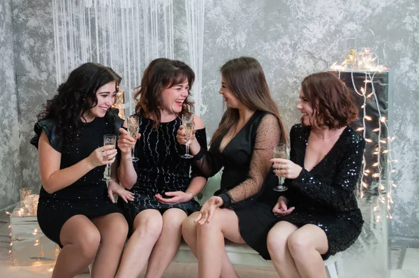 Compagnie de très belles jeunes femmes avec des verres de vin de champagne célèbre Noël, la nouvelle année. Regardez-vous, plaisantez et amusez-vous . — Photo