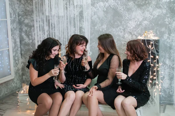 ?ompany de mujeres jóvenes muy agradables con copas de vino de champán celebra la Navidad, el año nuevo. Mirarse, bromear y divertirse . — Foto de Stock