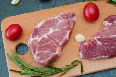 Domatesli çiğ et, sarımsak ve biberiye. Tahta kesme tahtasına yakın çekim, üst manzara.