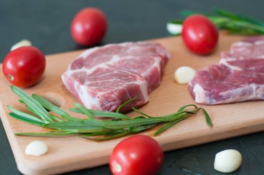 Kırmızı domatesli çiğ domuz bifteği, biberiye ve sarımsak..