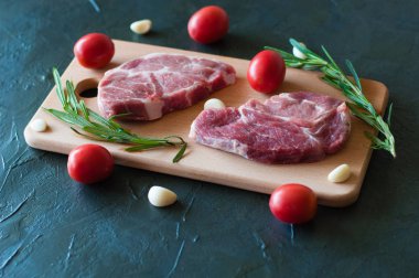 Çiğ domuz bifteği, kırmızı domates, biberiye ve sarımsak.