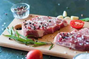 Biber ve tuz serpilmiş çiğ domuz eti doğranmış domates, sarımsak ve biberiye, biftek pişirme süreci.