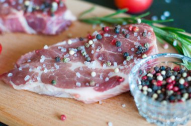 Biber ve tuz serpilmiş çiğ domuz eti, doğranmış domates ve biberiye pişirme süreci, yukarıdan görüş.