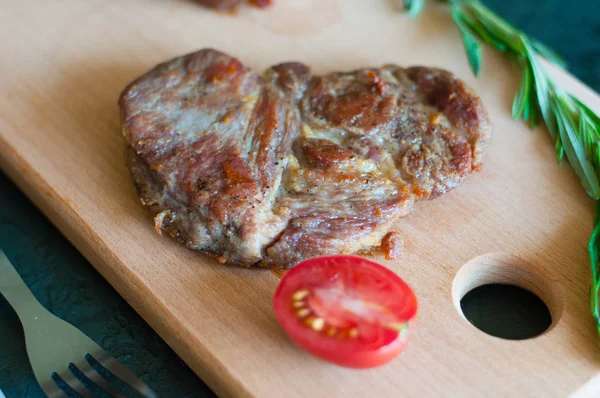 Biberiye, soya sosu ve domatesli domuz eti, sığır eti, ızgara biftek, kesme tahtası, çatal ve bıçak, yakın plan, üst görüş.