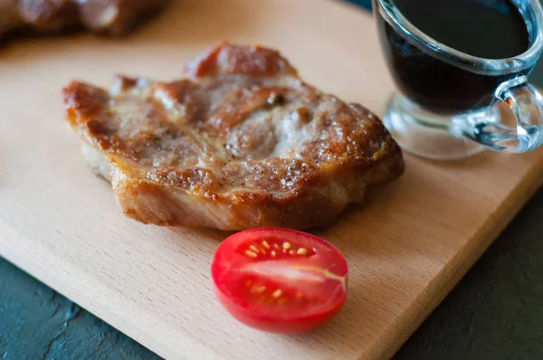 Šťavnatý grilovaný masový steak se sójovou omáčkou a plátkem rajčete, detailní záběr — Stock fotografie