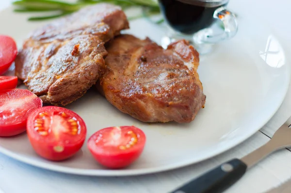 Bifes saborosos, suculentos e fritos de carne de porco ou de vaca com molho, especiarias e tomate — Fotografia de Stock