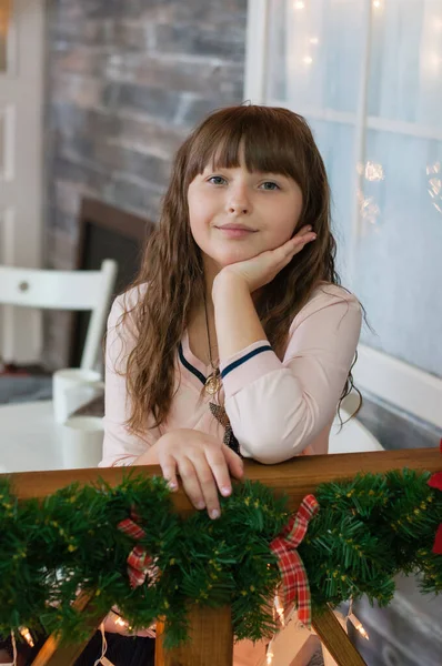 Retrato de uma menina adolescente na varanda da casa em casa decorada com guirlanda de Natal e decorações. Celebração do Ano Novo e Natal — Fotografia de Stock