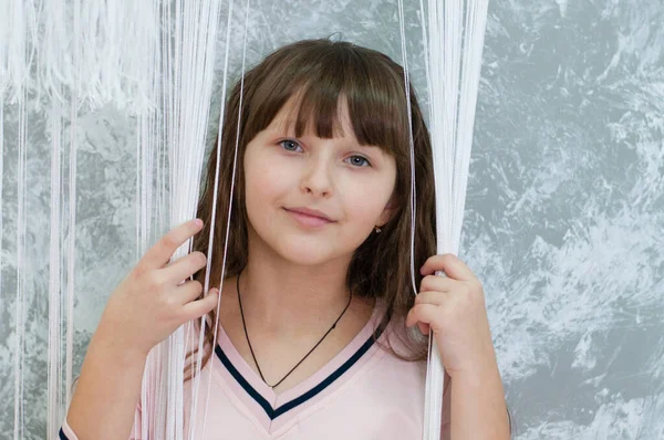 Vackra barn tonåring flicka på en grå vägg bakgrund, porträtt — Stockfoto