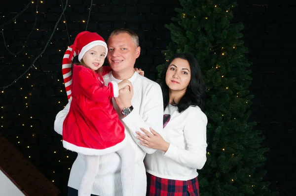 Happy family dad, mom and daughter near the New Year tree — ストック写真