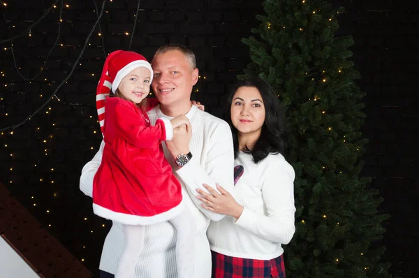 Happy family dad, mom and daughter near the New Year tree — ストック写真