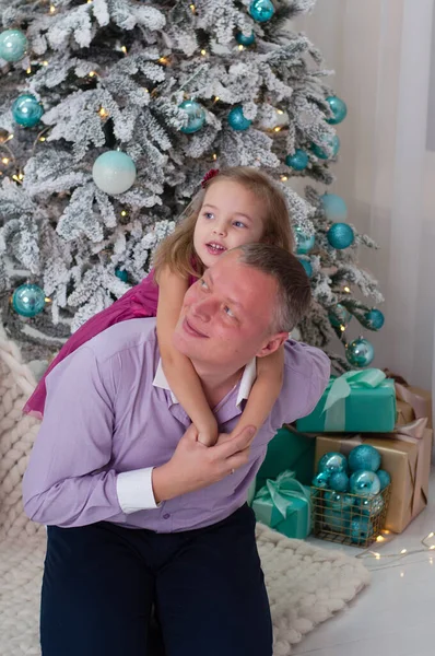 Papà gioca con sua figlia vicino all'albero di Capodanno — Foto Stock