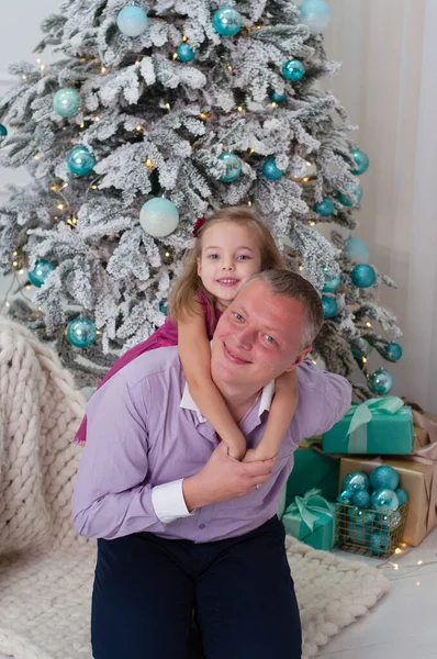 Papà gioca con sua figlia vicino all'albero di Capodanno — Foto Stock