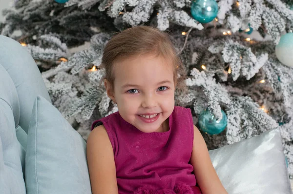 Enfant fille souriante près du sapin de Noël dans des tons turquoise — Photo