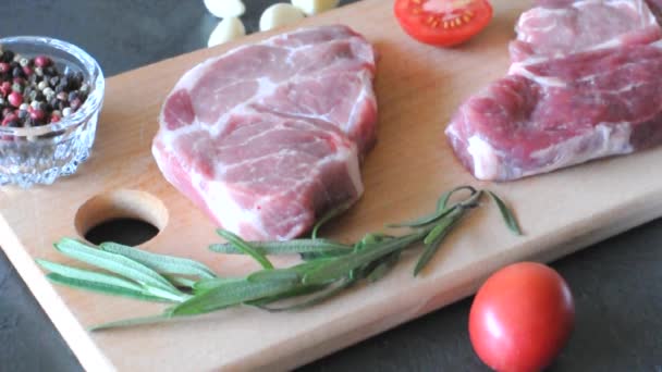 Filetes Cerdo Crudos Con Romero Ajo Sal Pimienta Tomates Sobre — Vídeo de stock