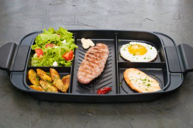 Kahvaltı, pirzola veya biftek, domates salatası, kızarmış patates, kızarmış ekmek ve kızarmış yumurta.