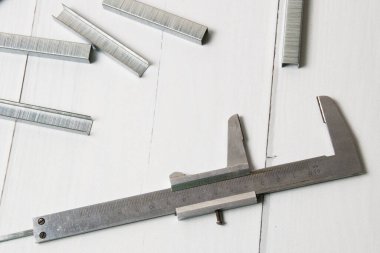 Yapı parantezleri ve cetvel açık tahta arka planda fotokopi alanı ile. İnşaat, onarım, konut koşullarının iyileştirilmesi