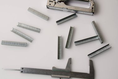 Yapı parantezleri, zımba ve cetvel. Arka planda fotokopi alanı var. İnşaat, onarım, konut koşullarının iyileştirilmesi