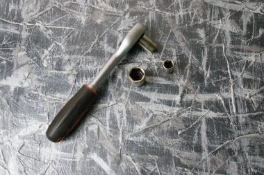 Gri arka planda farklı nozülleri olan eski soket anahtarı.