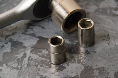 Cırcırlı eski soket anahtarı ve koyu gri arkaplanda metin için yeri olan farklı başlıklar.