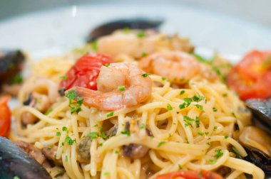 Karides, midye, domates ve peynirli spagetti makarna, yakın plan, yan görüş. Lezzetli, geleneksel İtalyan yemekleri.