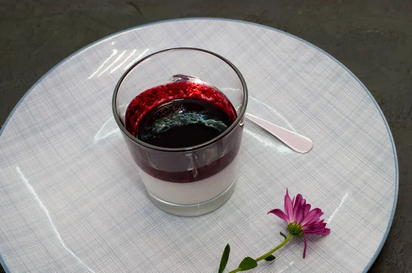 İtalyan şenlikli tatlı Panacotta, böğürtlenli, bardakta, kaşıkla