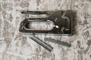 Tamir ve inşaat kavramı. Gri dekoratif macunun arka planında zımba bulunan zımba zımbası..