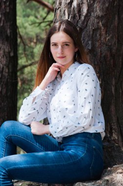 Yazın sıcak ve güneşli bir havada kozalaklı bir ormanda çok güzel bir genç kadın.