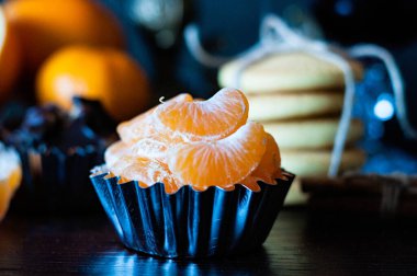 Kapalı mandalina dilimleri fırın kabında, kurabiyeler ve çikolata arka planda, Noel zamanı