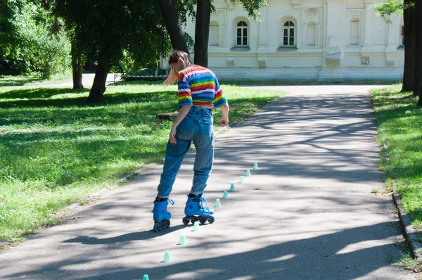 아름다운 아가씨가 여름에 공원에서 롤러스케이트를 비포니에의 트릭과 가지고 — 스톡 사진