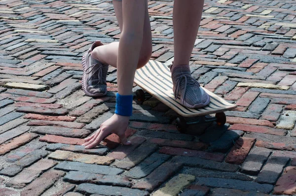 Красивые ноги молодой девушки на скейтборде крупным планом — стоковое фото