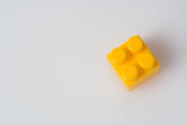 Kopya alanı olan beyaz bir arkaplanda sarı küp blok yapıcı. İnşaat fikri kavramı.