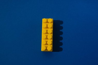 Mavi arkaplandaki inşaat işçisinin sarı detayı.