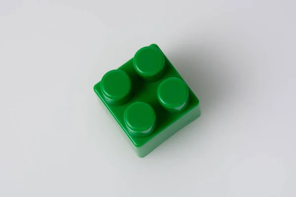 Beyaz arka planda yeşil blok inşaatçısı. İnşaat fikri kavramı