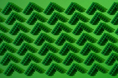 Yeşil zemin üzerinde bir plastik yapıcının birçok küçük parçasının deseni