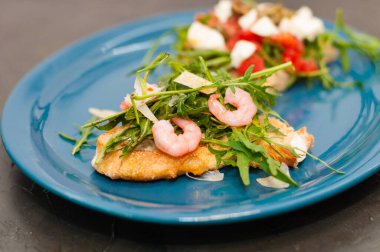 Karides, roka, domates, peynir ve sos, yakın plan, gri arka plan, yüksek İtalyan mutfağı.