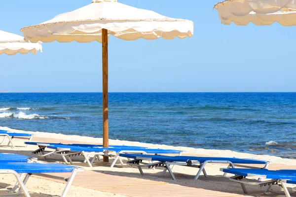 Şezlong ve şemsiyeler boş sahilde