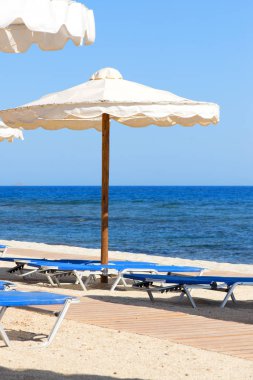 Şezlong ve şemsiyeler boş sahilde