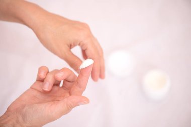 Nemlendirici el kremi ile bir kadının elleri