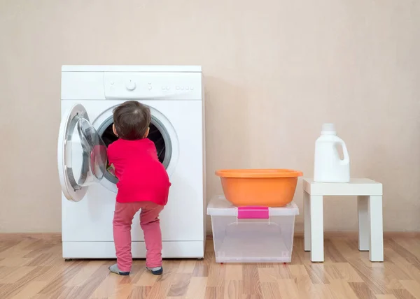 Ellerini Çamaşır Makinesinin Içine Sokan Küçük Bir Kız — Stok fotoğraf