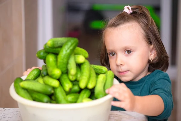 Liten Flicka Med Vit Skål Full Gurkor — Stockfoto