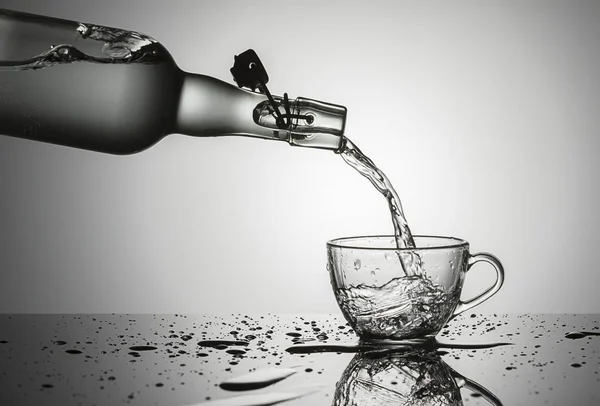 Концептуальное Изображение Заливки Воды Старой Стеклянной Бутылки Стеклянную Чашку — стоковое фото