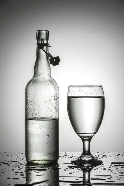 Una Foto Studio Acqua Bicchiere Accanto Una Bottiglia Acqua Vetro — Foto Stock