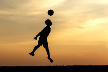 Genç bir atlet bu konsept fotoğraf gün batımında bir futbol topu kafa.