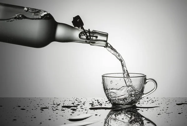 Концептуальное Изображение Заливки Воды Старой Стеклянной Бутылки Стеклянную Чашку — стоковое фото