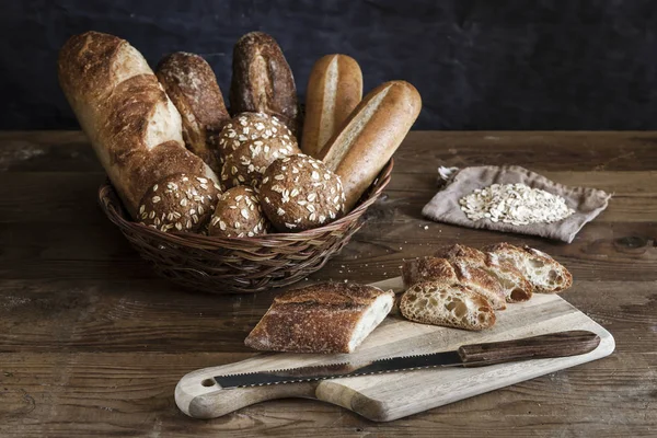 Bir Sepet Kesme Tahtası Üzerinde Bir Baget Ekmek Çeşitleri — Stok fotoğraf